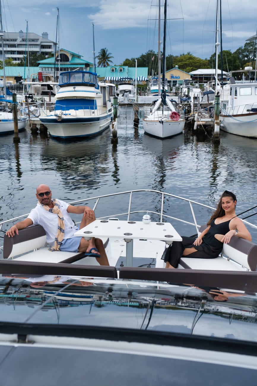 Two guests sitting on the bow lounge at the marina