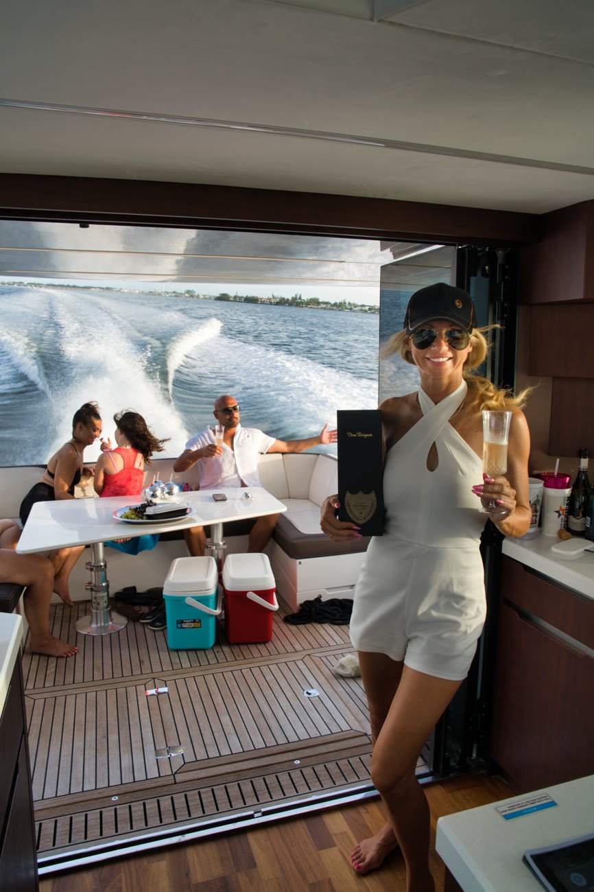 Guests around the aft deck table with the wake streaming out behind the yacht